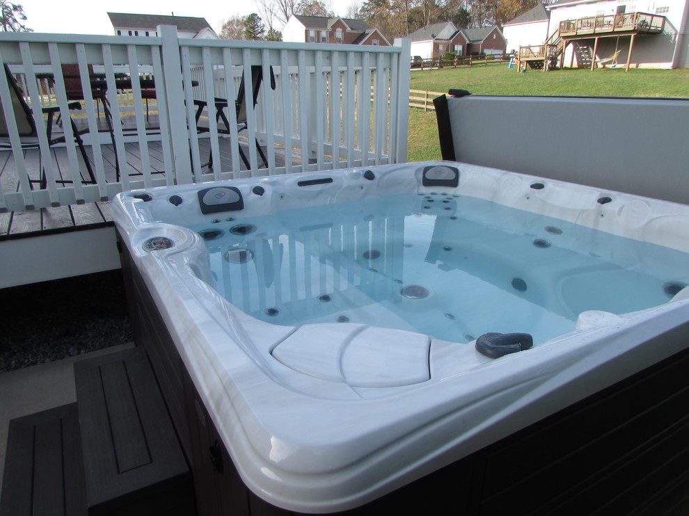 Example of a large transitional backyard water fountain deck design with no cover