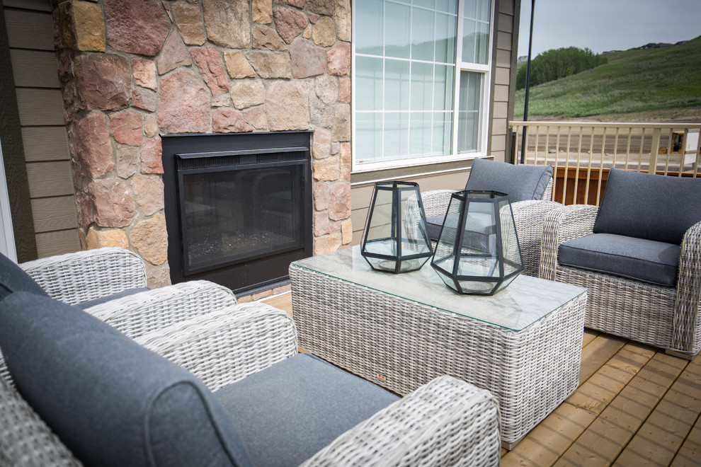 Photo of a mid-sized country backyard deck in Calgary with a fire feature and no cover.