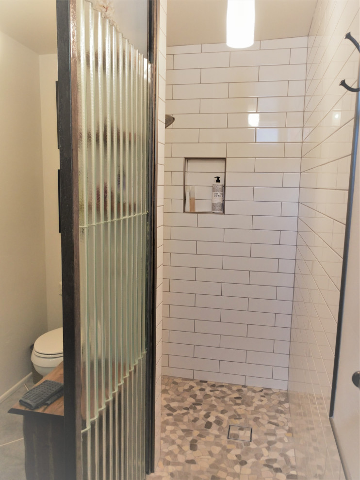 Photo of a small modern master bathroom in Phoenix with open cabinets, an open shower, a two-piece toilet, white tile, subway tile, white walls, concrete floors, a drop-in sink, tile benchtops, grey floor and an open shower.