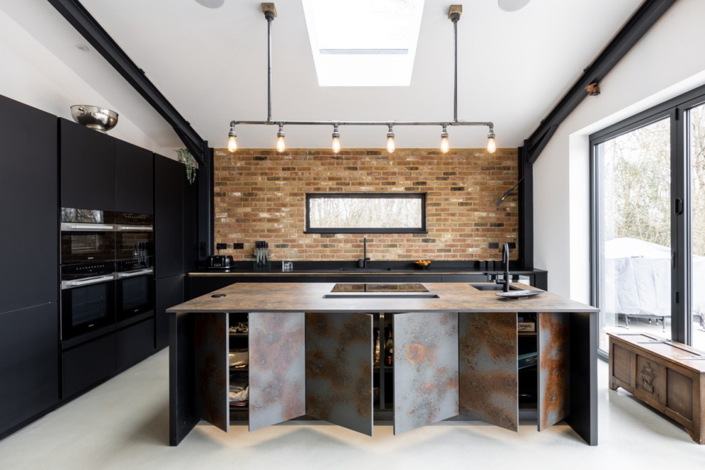 Immagine di una cucina industriale di medie dimensioni con ante lisce, ante nere, top in quarzo composito, elettrodomestici neri, pavimento in cemento e top nero