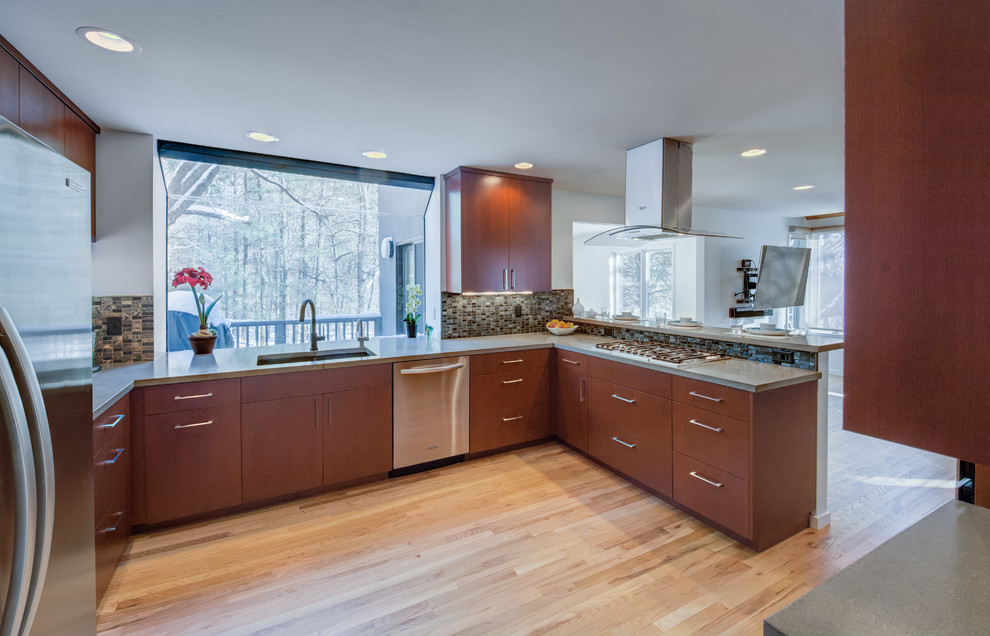 Photo of a contemporary u-shaped kitchen in Detroit with a double-bowl sink, flat-panel cabinets, dark wood cabinets, concrete benchtops, grey splashback, stone tile splashback and light hardwood floors.