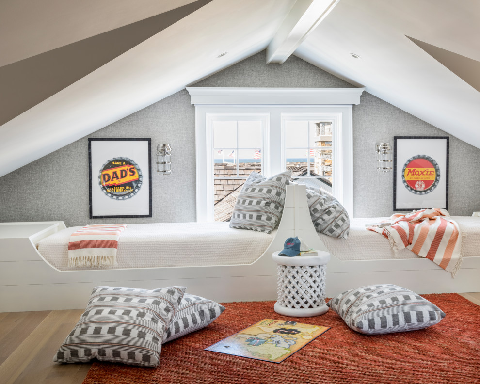 Photo of a beach style gender-neutral kids' bedroom for kids 4-10 years old in New York with grey walls and light hardwood floors.