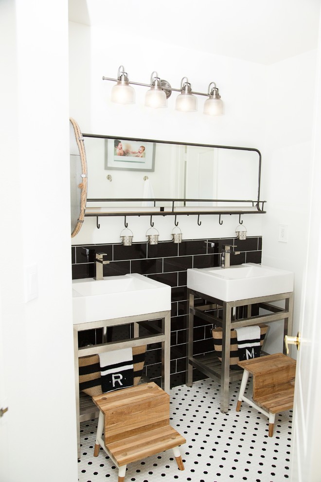 Inspiration for a mid-sized industrial kids' black tile and subway tile porcelain tile and white floor bathroom remodel in Other with a one-piece toilet, white walls, an integrated sink and solid surface countertops