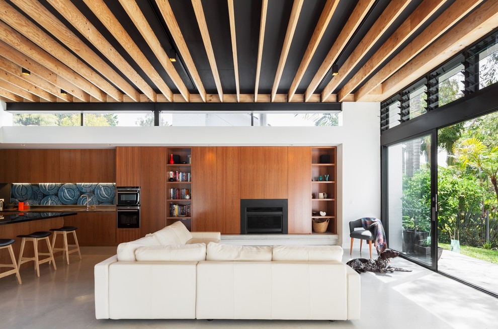 Contemporary open concept living room in Sydney with white walls, a standard fireplace and grey floor.