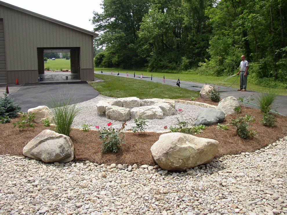 Inspiration for a rustic stone landscaping in Cincinnati with a fire pit.