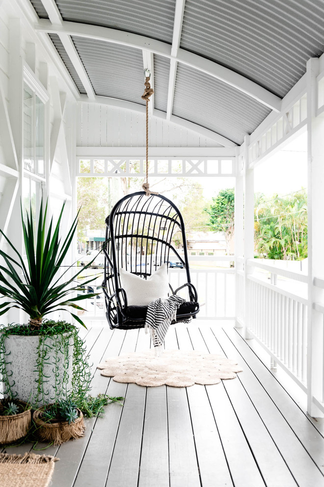 This is an example of a beach style deck in Brisbane with a roof extension.
