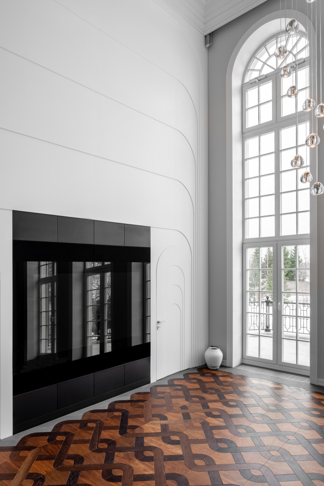 Идея дизайна: объединенная гостиная комната среднего размера, в белых тонах с отделкой деревом в стиле неоклассика (современная классика) с белыми стенами, подвесным камином, фасадом камина из металла, скрытым телевизором, зоной отдыха и коричневым полом