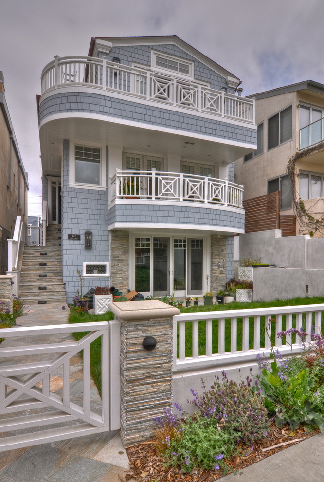 Photo of a mid-sized beach style three-storey blue exterior in Los Angeles with wood siding.
