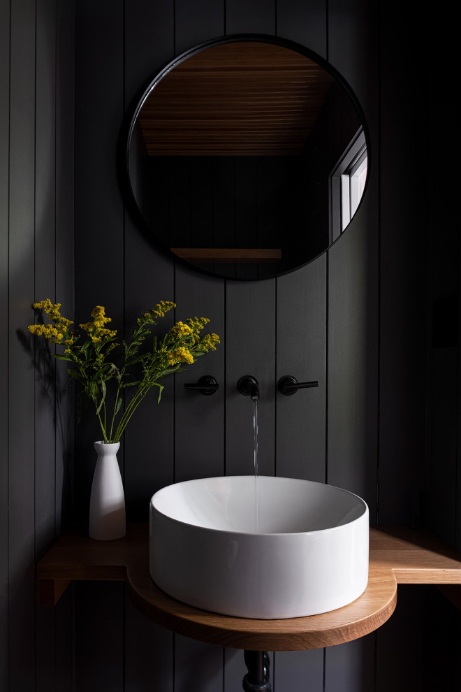 Esempio di un bagno di servizio tradizionale con WC monopezzo, pareti nere, lavabo a bacinella, top in legno, soffitto in legno e pareti in perlinato