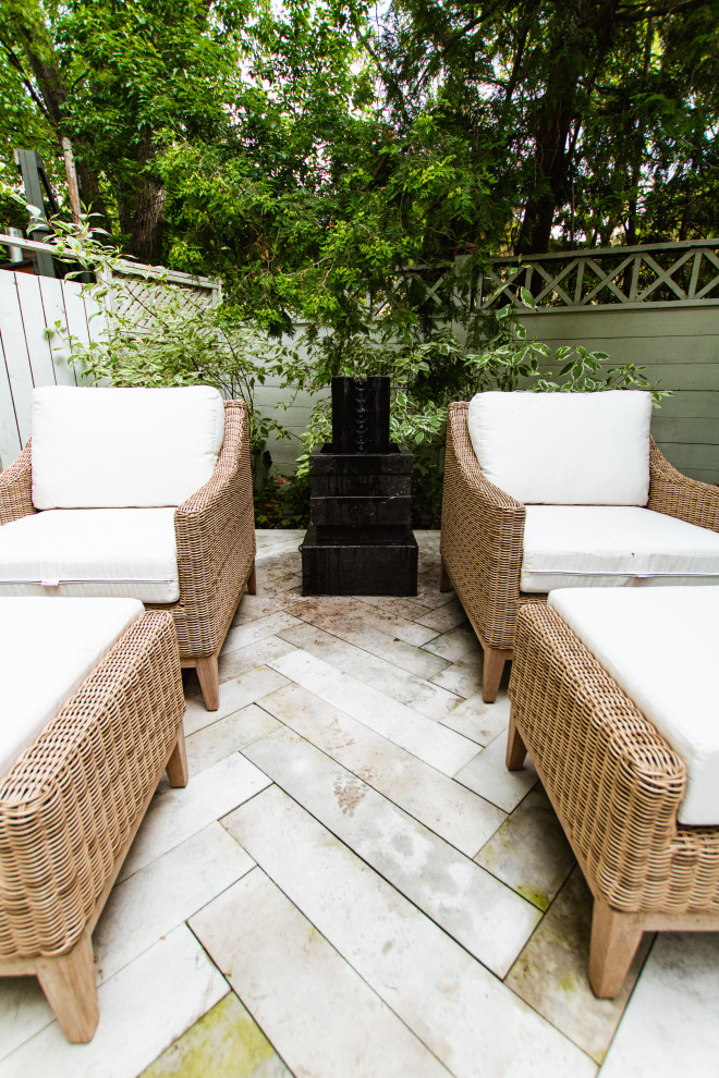 Photo of a mid-sized contemporary backyard partial sun formal garden in Toronto with natural stone pavers.