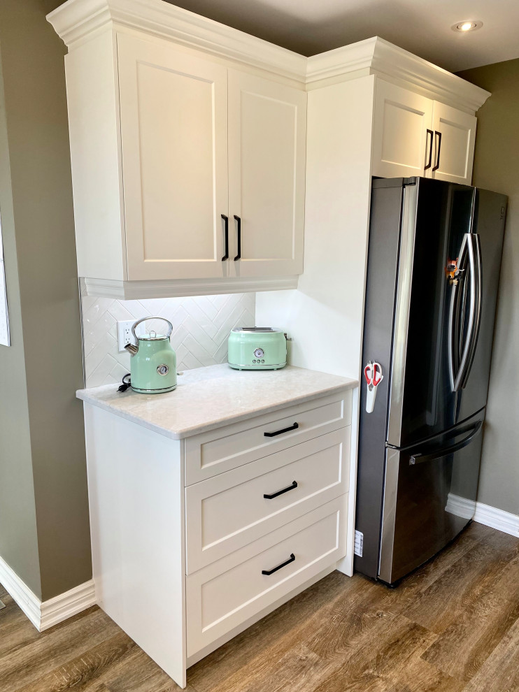 Inspiration for a mid-sized transitional l-shaped enclosed kitchen remodel with a double-bowl sink, recessed-panel cabinets, white cabinets, gray backsplash, glass tile backsplash and no island