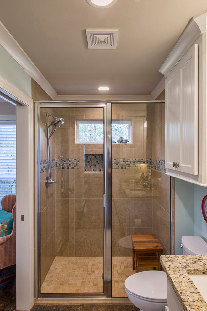 Design ideas for a small country master bathroom in Other with shaker cabinets, white cabinets, a curbless shower, a two-piece toilet, brown tile, ceramic tile, blue walls, concrete floors, an undermount sink, granite benchtops, black floor, a hinged shower door and beige benchtops.
