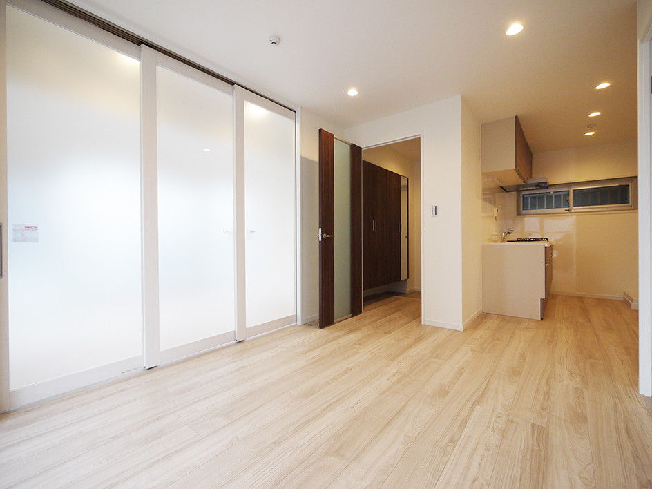 Modern open concept living room in Tokyo with white walls, light hardwood floors and beige floor.