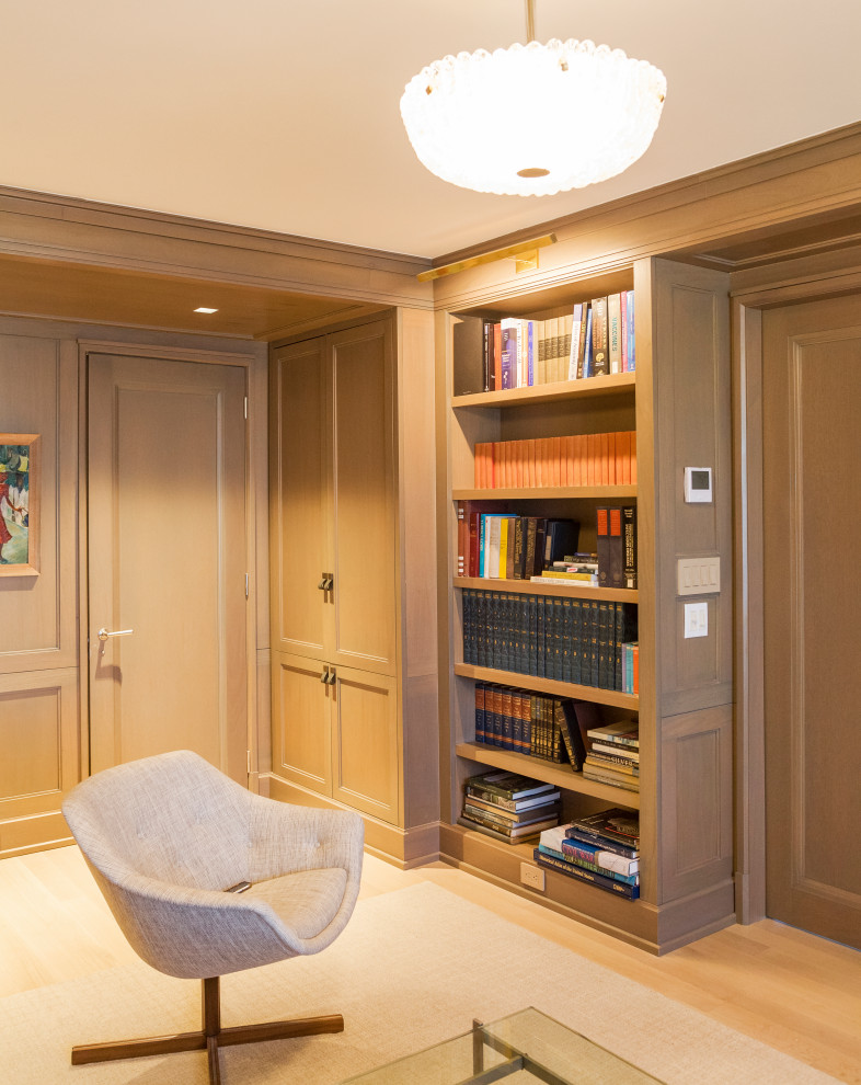 This is an example of a medium sized modern enclosed games room in New York with a reading nook, beige walls, light hardwood flooring, beige floors and wood walls.