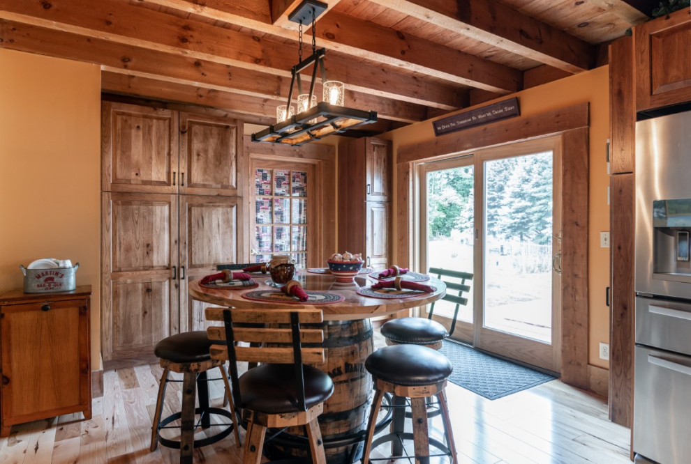 Kitchen - rustic l-shaped medium tone wood floor kitchen idea in Boston with an undermount sink, raised-panel cabinets, medium tone wood cabinets, granite countertops, gray backsplash, stainless steel appliances, an island and black countertops