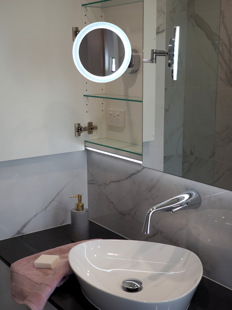 Inspiration for a mid-sized contemporary master bathroom in Brisbane with flat-panel cabinets, white cabinets, a curbless shower, marble, porcelain floors, a vessel sink, engineered quartz benchtops, beige floor, a hinged shower door and black benchtops.