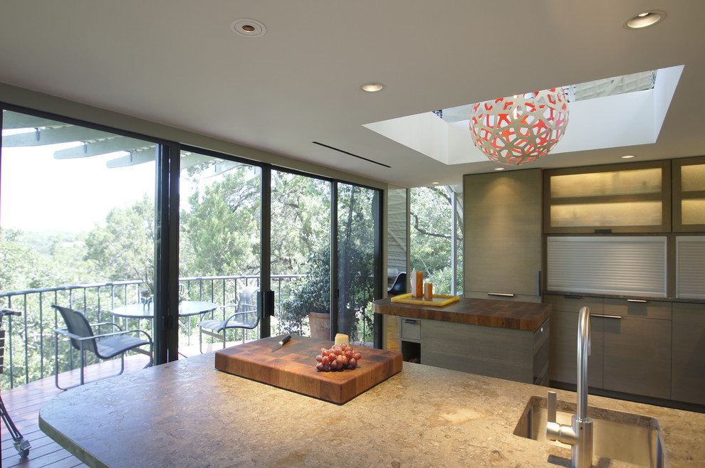 Design ideas for a mid-sized modern u-shaped separate kitchen in Austin with a single-bowl sink, flat-panel cabinets, grey cabinets, limestone benchtops, multi-coloured splashback, mosaic tile splashback, panelled appliances, cork floors and with island.