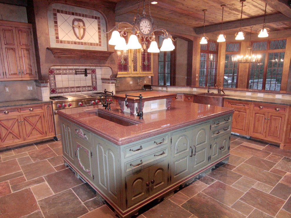Large eclectic u-shaped slate floor eat-in kitchen photo with a farmhouse sink, raised-panel cabinets, distressed cabinets, granite countertops, terra-cotta backsplash, paneled appliances and an island