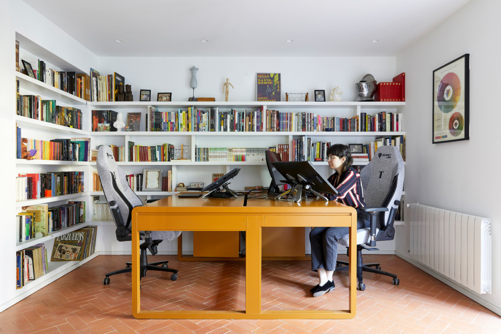 Foto di uno studio mediterraneo di medie dimensioni con libreria, pareti bianche, pavimento in mattoni, nessun camino, scrivania autoportante e pavimento rosso