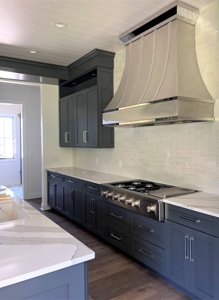 Kitchen - large transitional kitchen idea with an undermount sink, shaker cabinets, gray cabinets, quartz countertops, white backsplash, stainless steel appliances, two islands and white countertops
