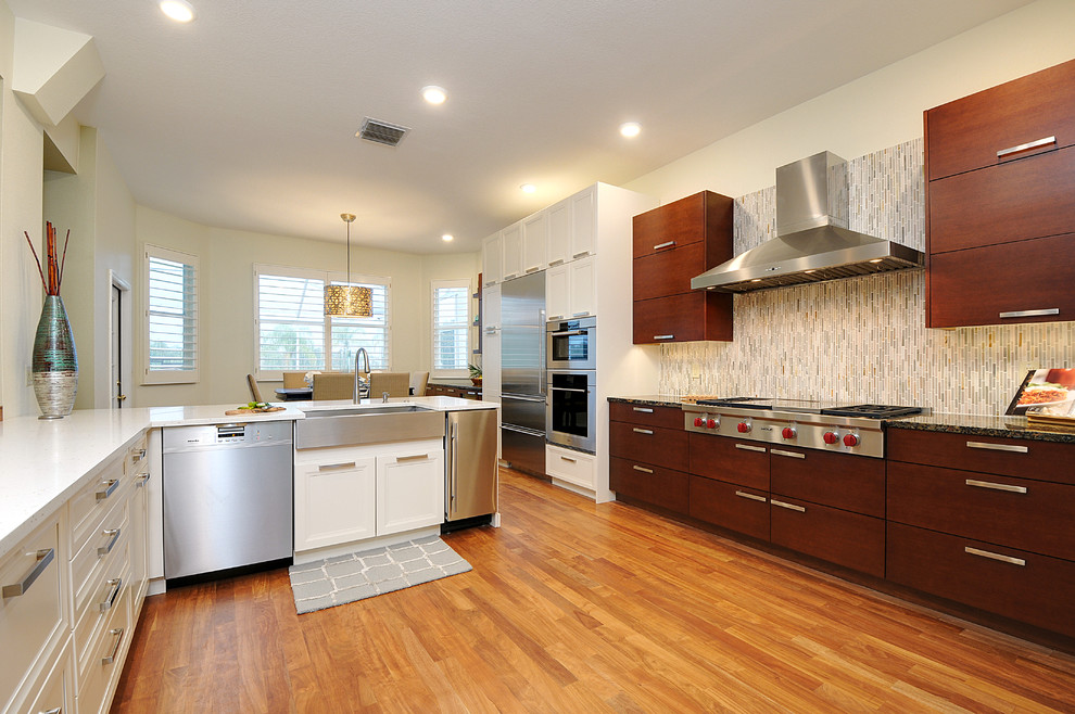 Example of a large transitional l-shaped dark wood floor open concept kitchen design in Tampa with a farmhouse sink, gray backsplash, matchstick tile backsplash, stainless steel appliances and an island