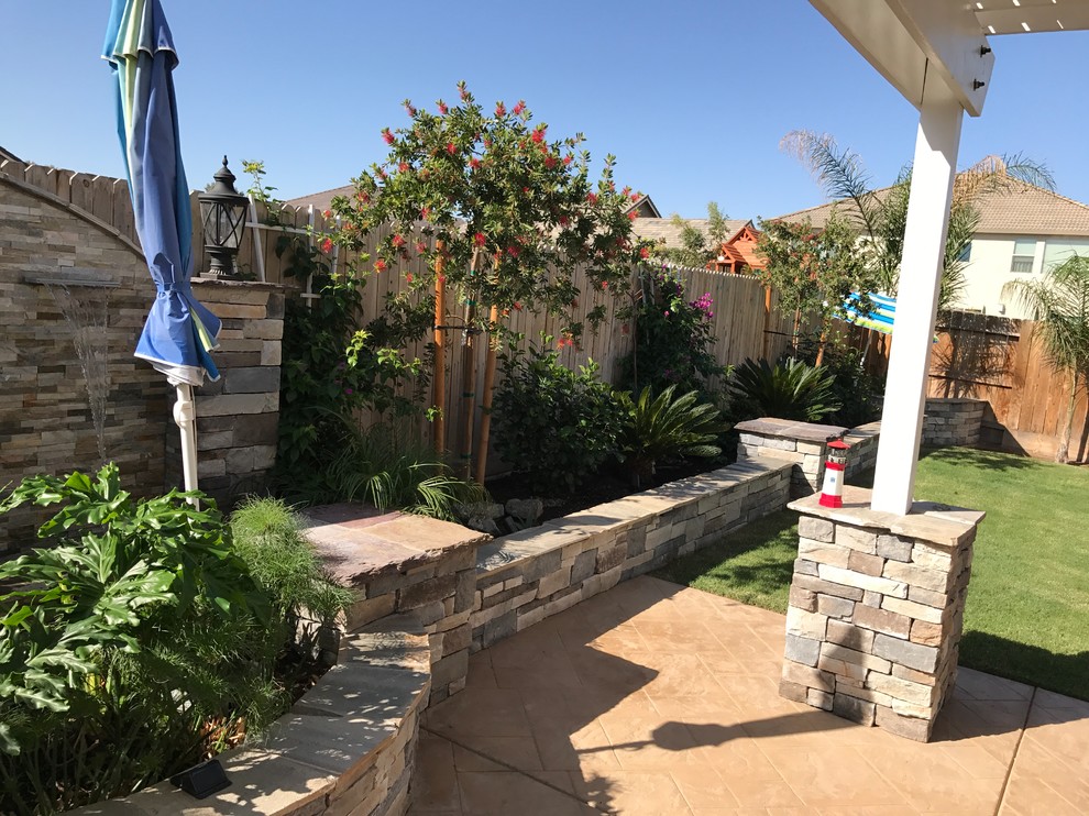 Mid-sized transitional backyard stone patio photo