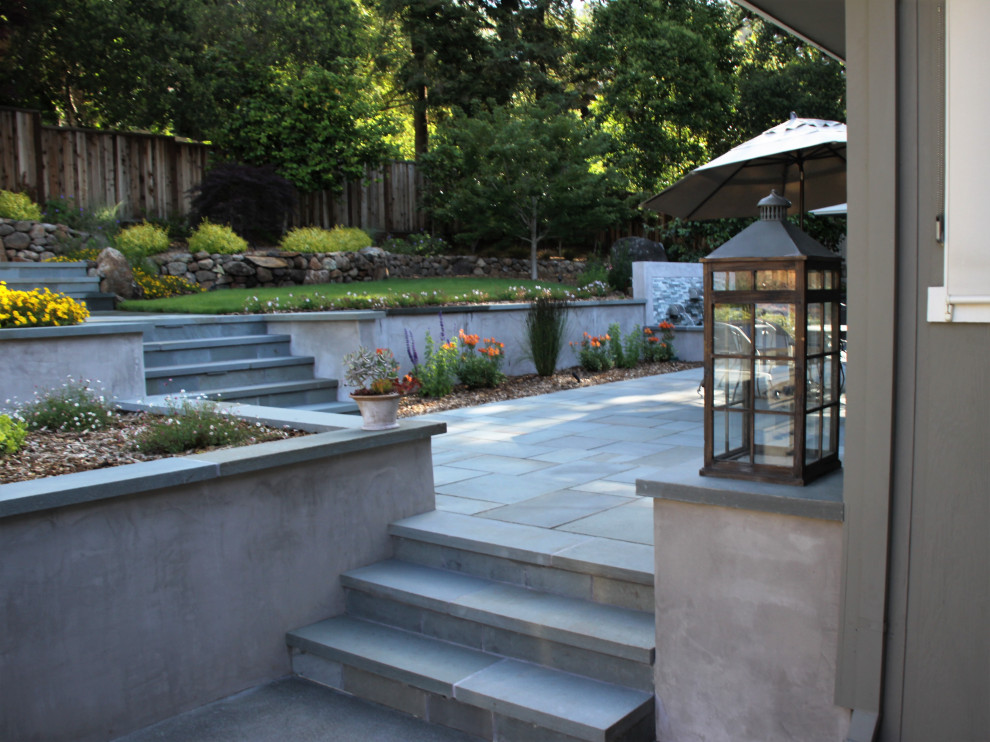 На фото: двор на заднем дворе в современном стиле с фонтаном и покрытием из каменной брусчатки