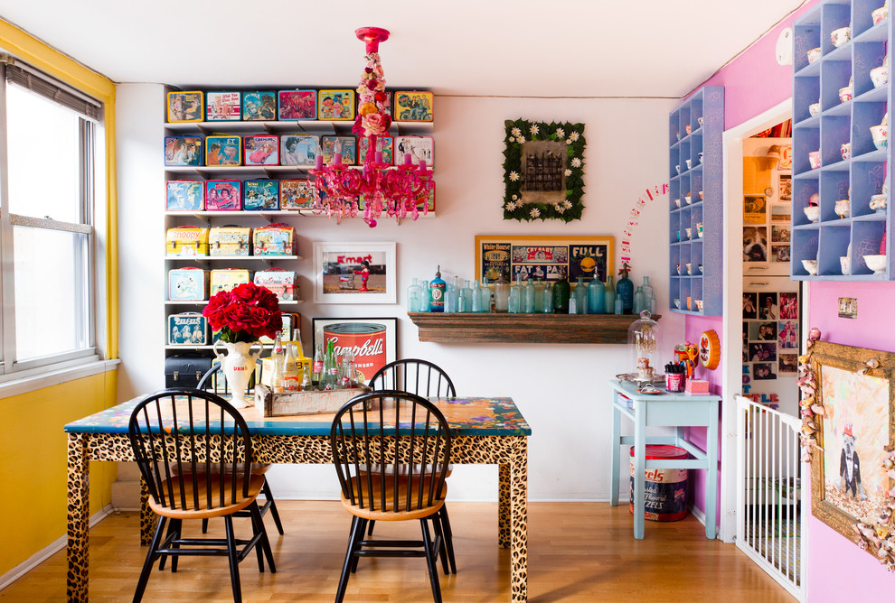 Eclectic dining room in New York with medium hardwood floors and multi-coloured walls.