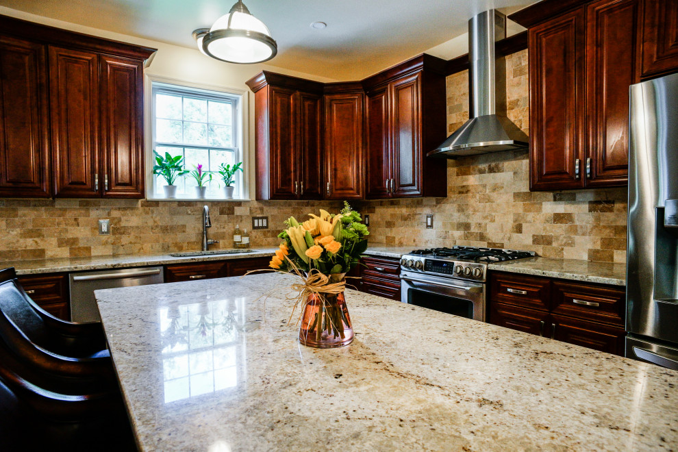 Bild på ett beige beige kök, med en undermonterad diskho, luckor med upphöjd panel, röda skåp, granitbänkskiva, beige stänkskydd, stänkskydd i stenkakel, ljust trägolv, en köksö och gult golv