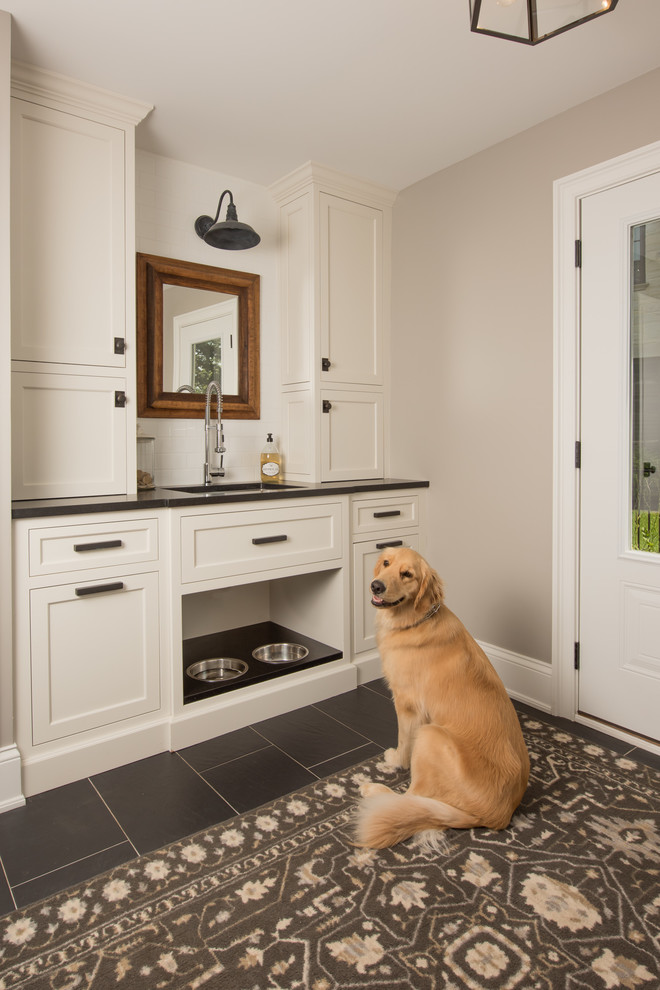 This is an example of a mid-sized traditional mudroom in Chicago with ceramic floors, black floor and grey walls.