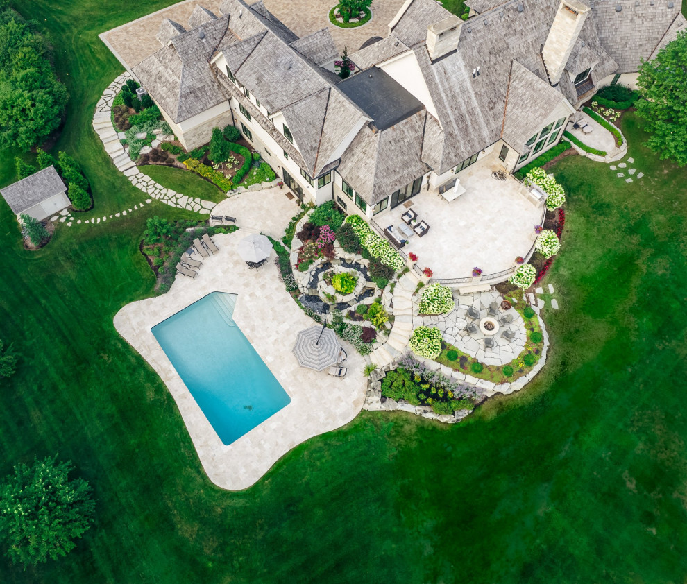 Example of a mountain style backyard stone and rectangular pool landscaping design in Chicago