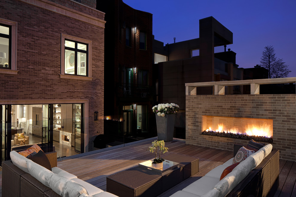 Large transitional rooftop deck photo in Chicago with a fire pit and no cover