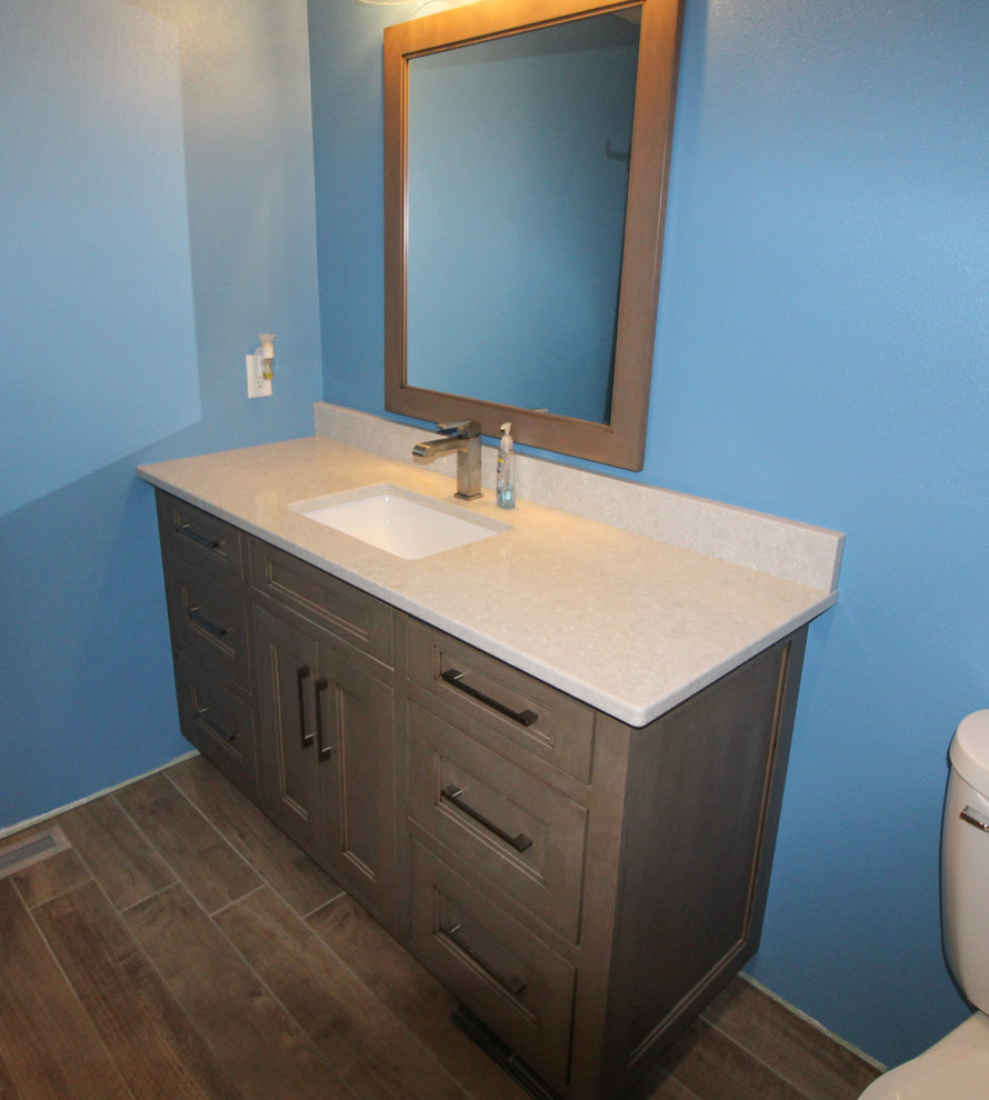 Transitional kids' ceramic tile and brown floor home design photo with recessed-panel cabinets, brown cabinets, blue walls, an undermount sink, quartz countertops and beige countertops