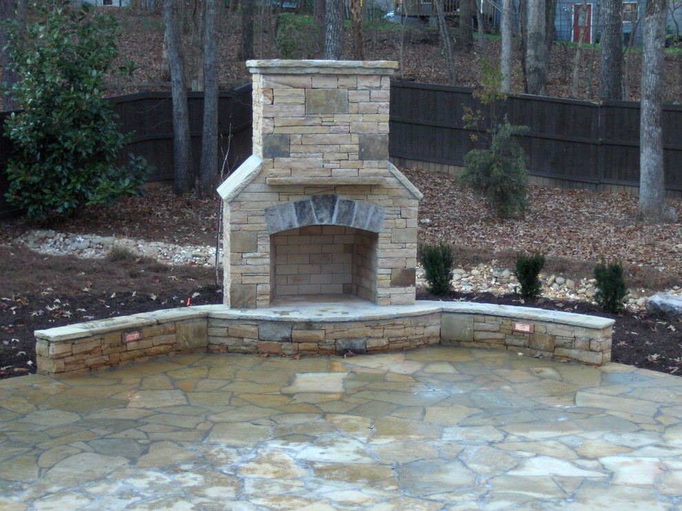 This is an example of a large traditional backyard partial sun garden in Atlanta with a fire feature and natural stone pavers.