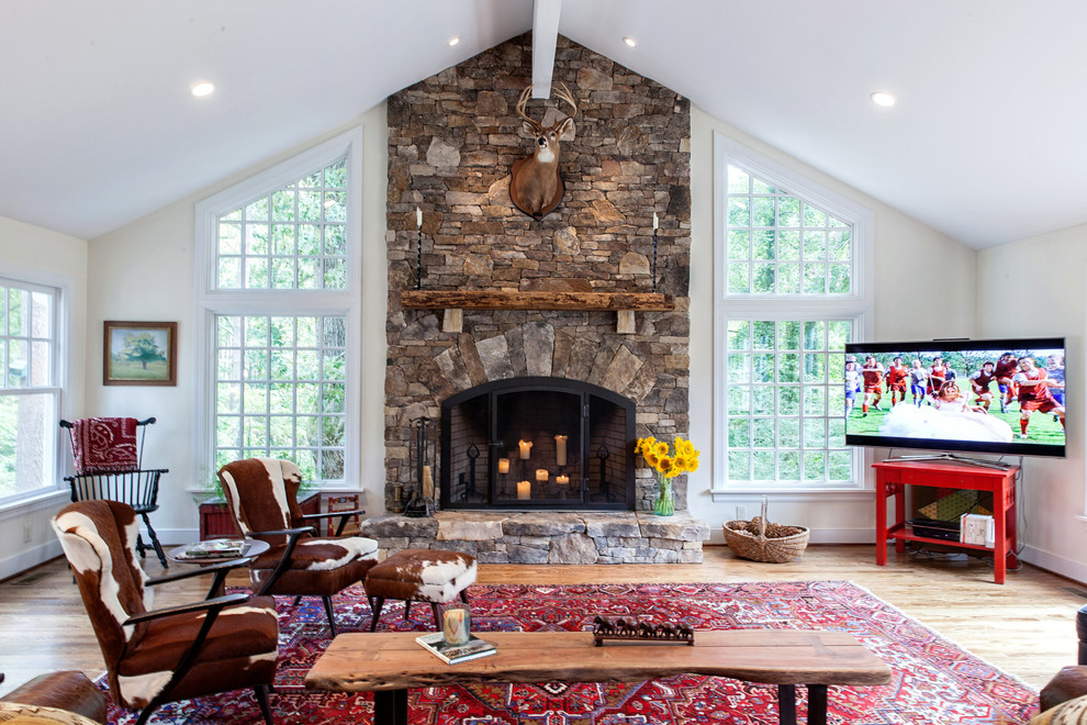 Inspiration for a traditional living room in Richmond with medium hardwood floors, a standard fireplace, a stone fireplace surround and a freestanding tv.