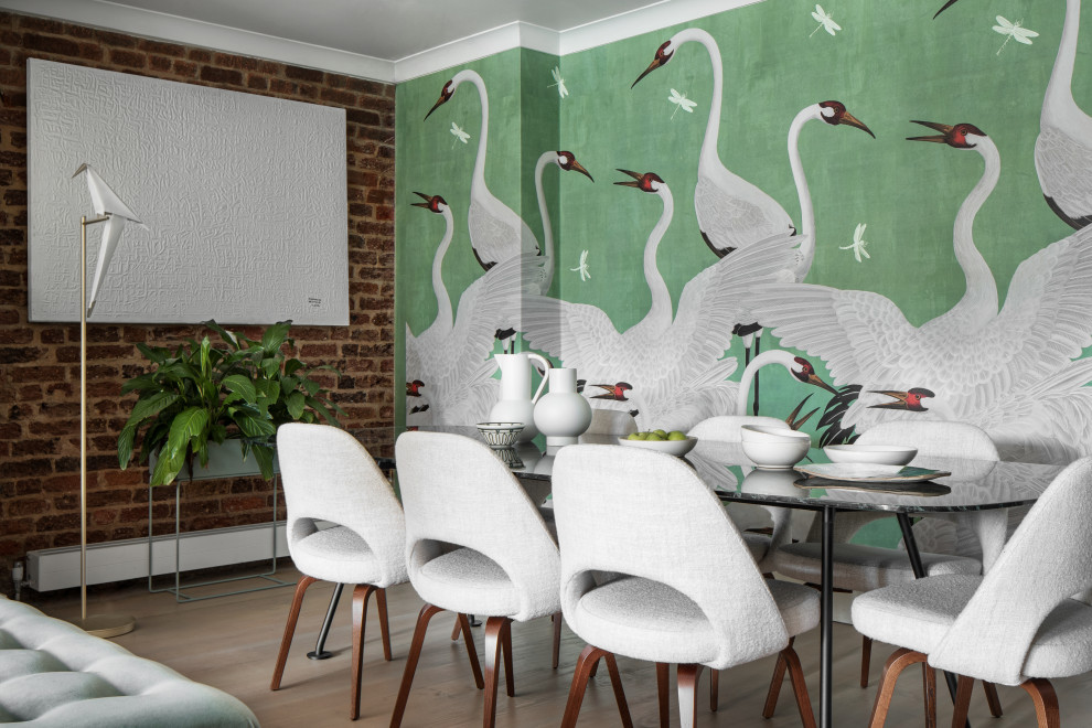 Photo of a transitional dining room in London with green walls, light hardwood floors, beige floor, brick walls and wallpaper.