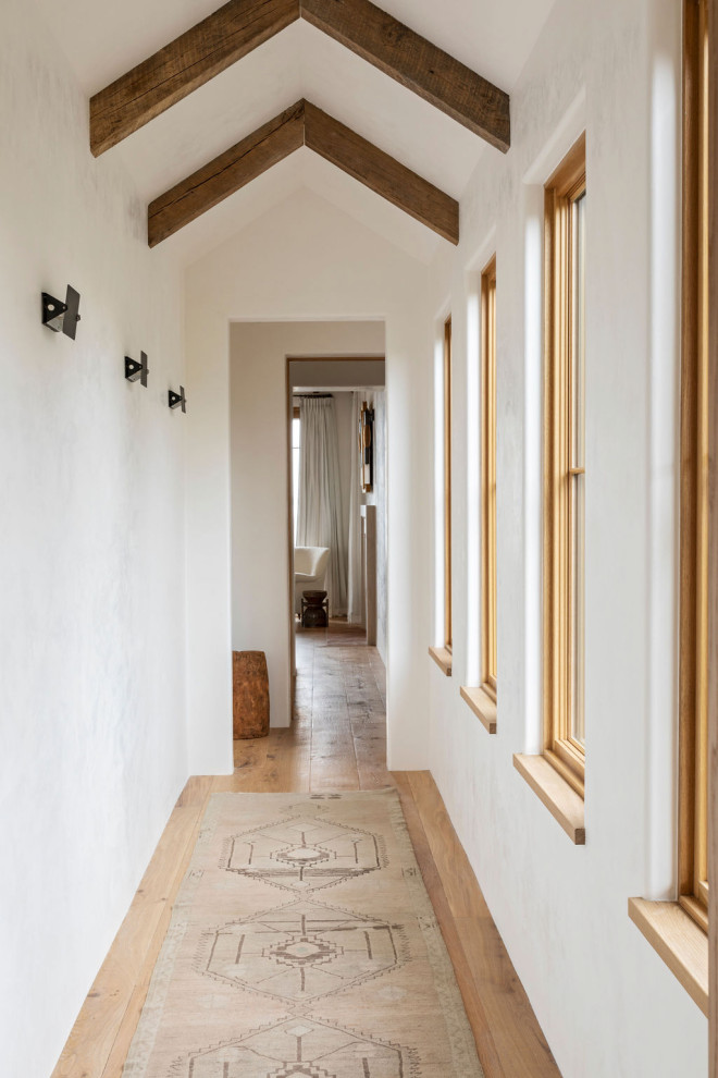 Стильный дизайн: коридор среднего размера в средиземноморском стиле с белыми стенами, светлым паркетным полом, коричневым полом и балками на потолке - последний тренд