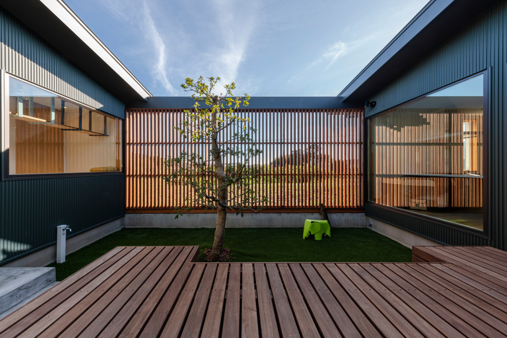 Idée de décoration pour un jardin nordique de taille moyenne et l'été avec des solutions pour vis-à-vis, une exposition ensoleillée, une terrasse en bois et une clôture en bois.
