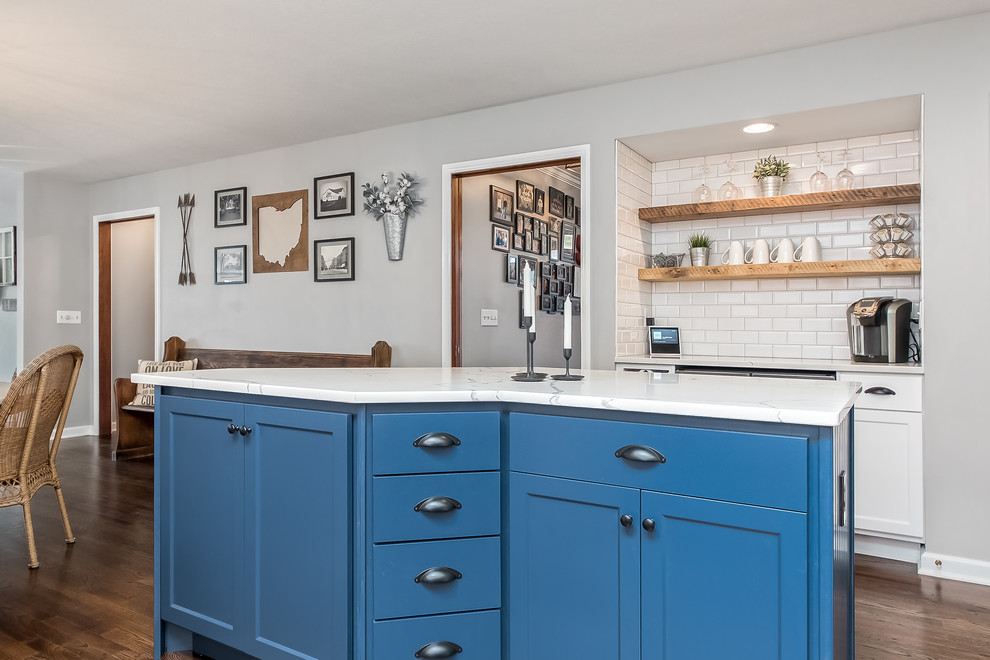 Example of a large transitional u-shaped eat-in kitchen design in Columbus with shaker cabinets, quartz countertops, white backsplash and an island