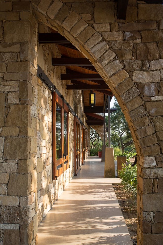 This is an example of a large industrial one-storey brown exterior in Austin with stone veneer and a gable roof.