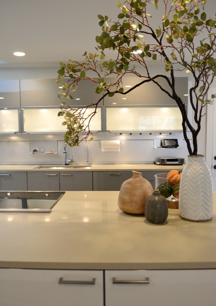 Example of a large transitional medium tone wood floor eat-in kitchen design in Indianapolis with an undermount sink, white cabinets, quartzite countertops, gray backsplash, metal backsplash and paneled appliances