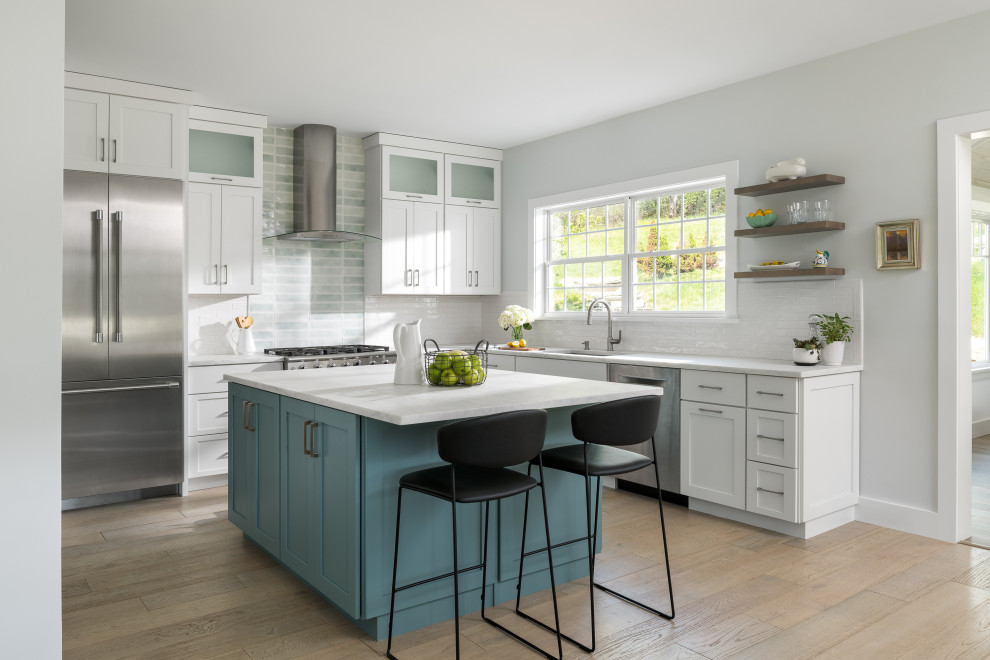 Eat-in kitchen - mid-sized transitional l-shaped eat-in kitchen idea in Burlington with an undermount sink, shaker cabinets, white cabinets, marble countertops, subway tile backsplash, stainless steel appliances, an island and white countertops