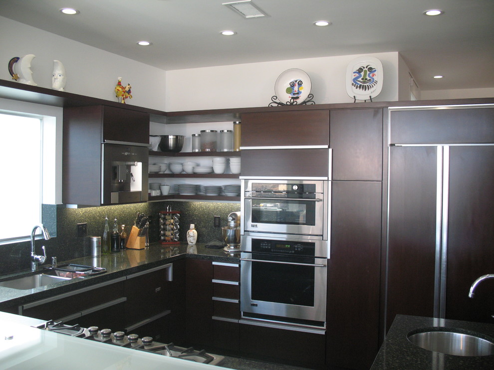 Inspiration for a mid-sized contemporary u-shaped separate kitchen in San Diego with flat-panel cabinets, dark wood cabinets, glass benchtops, panelled appliances, slate floors, a peninsula and grey floor.