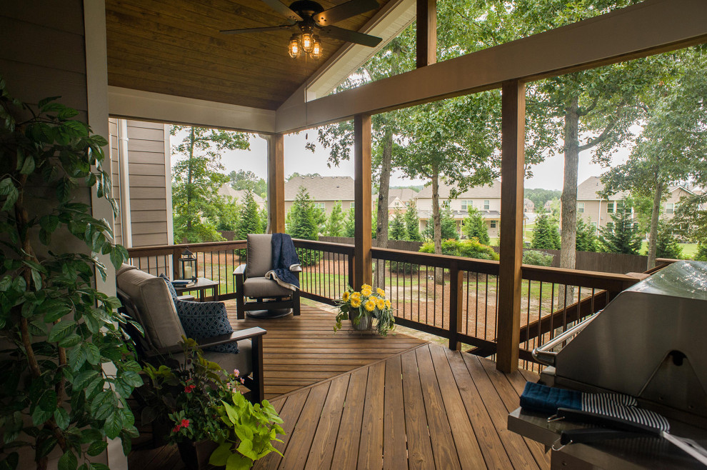 Cette image montre un porche d'entrée de maison arrière traditionnel de taille moyenne avec une terrasse en bois, une extension de toiture et un garde-corps en matériaux mixtes.
