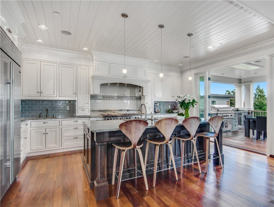 Open concept kitchen - mid-sized transitional l-shaped dark wood floor and brown floor open concept kitchen idea with a single-bowl sink, beaded inset cabinets, white cabinets, granite countertops, blue backsplash, glass tile backsplash, stainless steel appliances and an island