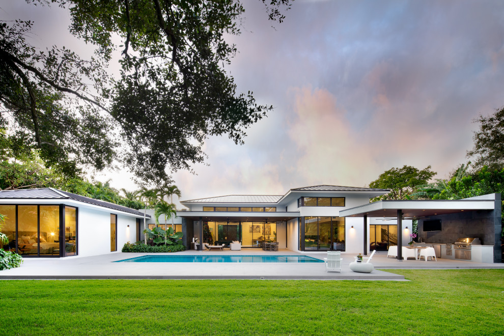 Expansive contemporary backyard patio in Miami with an outdoor kitchen and concrete slab.