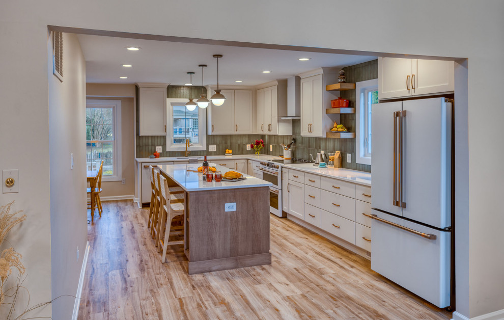 This is an example of a large transitional kitchen in DC Metro with flat-panel cabinets, white cabinets, quartz benchtops, green splashback, ceramic splashback, with island and white benchtop.