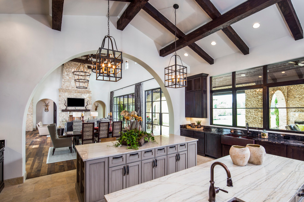 Example of a large mountain style brown floor open concept kitchen design in Austin with recessed-panel cabinets, light wood cabinets and two islands