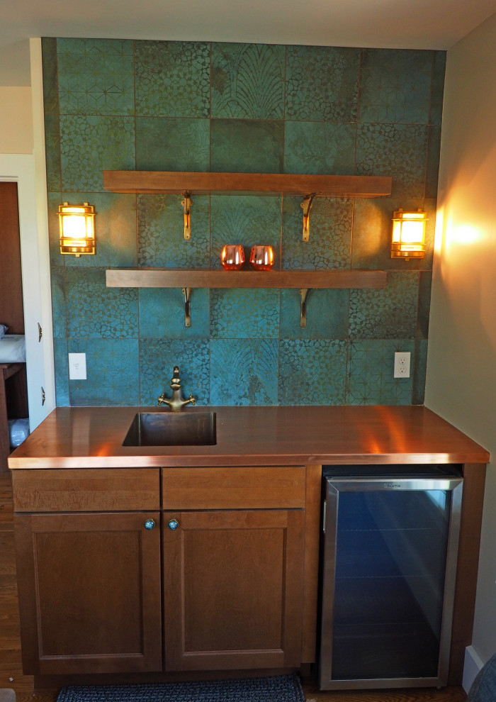 This is an example of a small traditional single-wall wet bar in Burlington with an integrated sink, shaker cabinets, copper benchtops, green splashback and porcelain splashback.