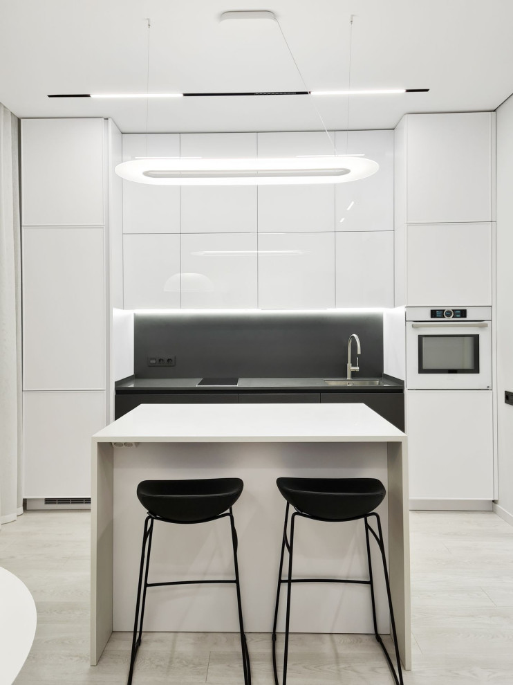 Bild på ett litet funkis vit linjärt vitt kök och matrum, med vita skåp, bänkskiva i koppar, svart stänkskydd, vinylgolv, en köksö och vitt golv